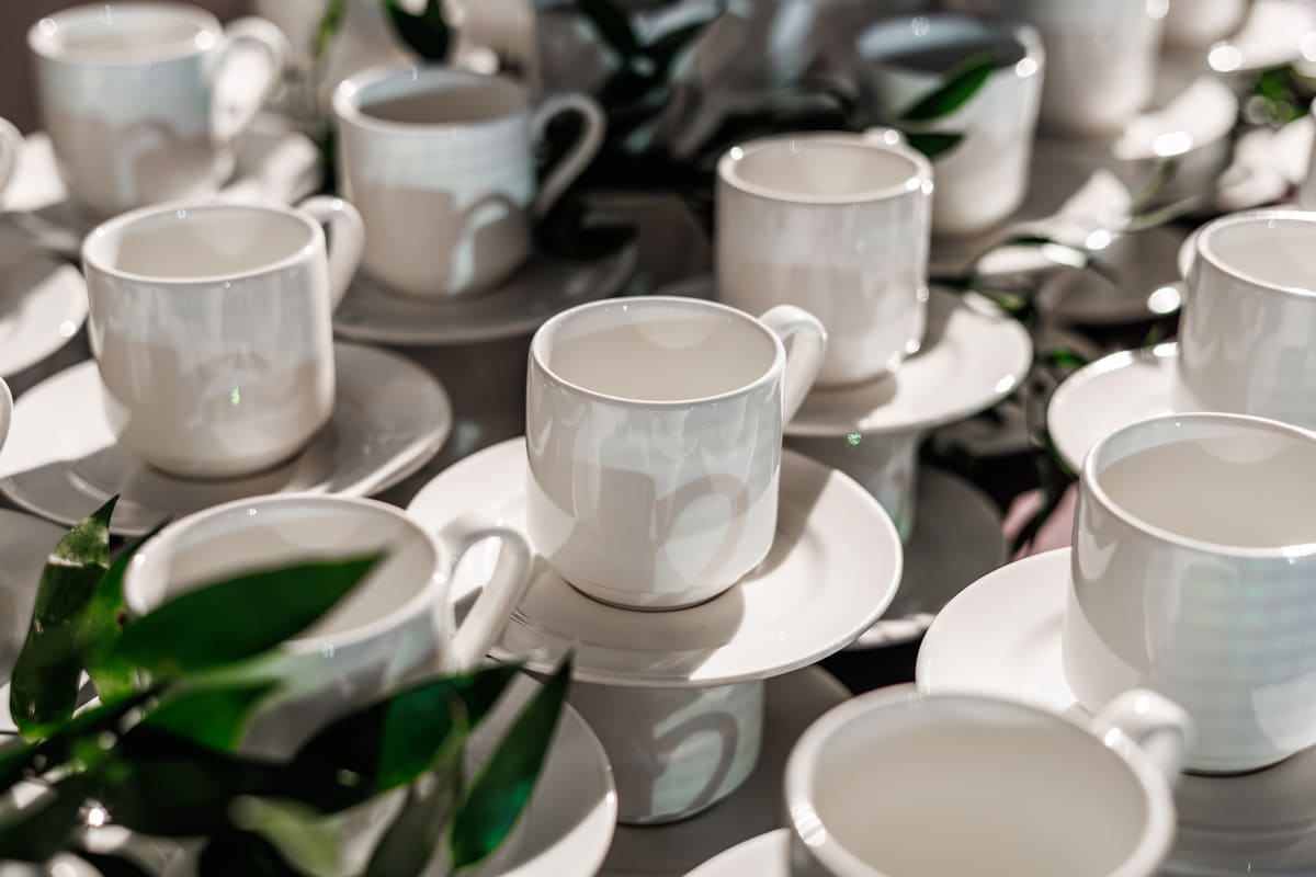 Set aus weißen Porzellantassen mit Untertassen