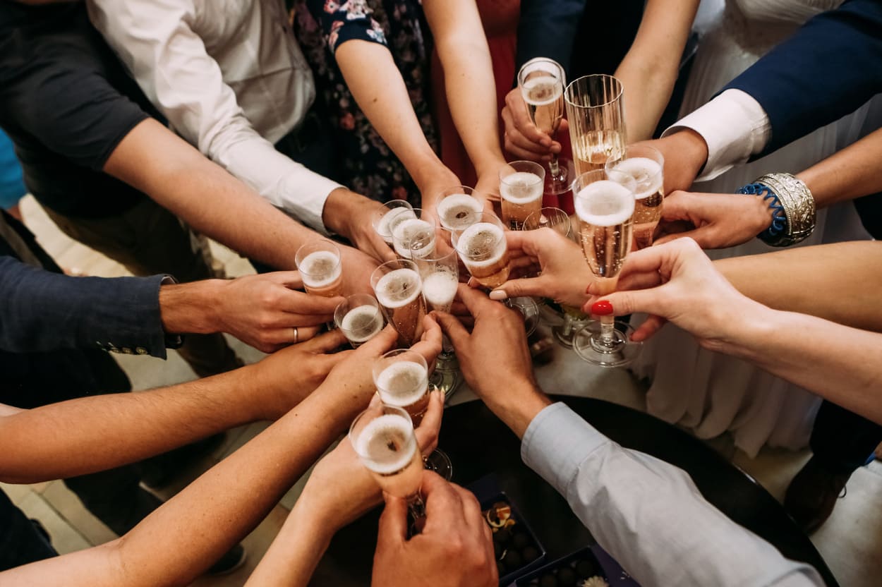 Gemeinsam auf das Firmenjubiläum anstoßen: Gäste feiern mit Champagner einen besonderen Meilenstein des Unternehmens.