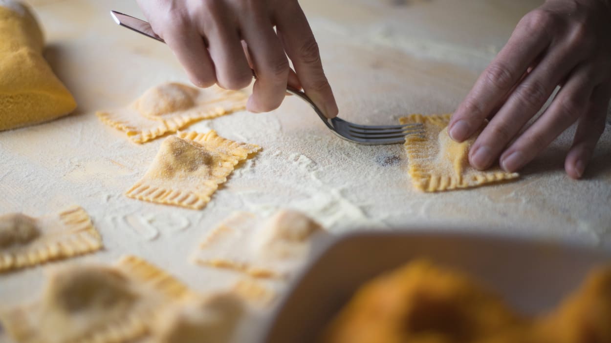 Italienischen Kochkurs planen: Bei der gemeinsamen Zubereitung von hausgemachter Pasta lernen Teilnehmer Schritt für Schritt, Ravioli selbst herzustellen.